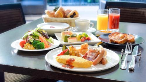 a table with plates of food on a table at RIHGA Royal Hotel Osaka, Vignette Collection by IHG in Osaka