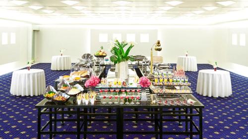 a buffet of food in a room with two tables at RIHGA Royal Hotel Osaka, Vignette Collection by IHG in Osaka