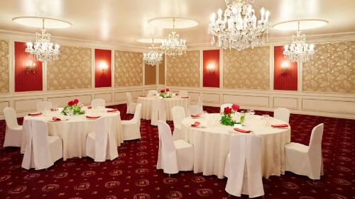 a banquet room with white tables and chairs and chandeliers at RIHGA Royal Hotel Osaka, Vignette Collection by IHG in Osaka