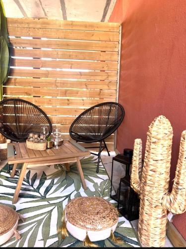 une terrasse avec deux chaises, une table et un cactus dans l'établissement Résidence hôtelière les hameaux de saint cyprien 25 M2, à Lecci