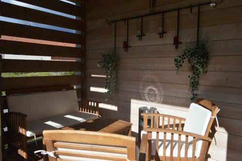 un patio avec deux chaises, une table et un banc dans l'établissement Chalet de la Royotte - Sauna & SPA, à Gérardmer