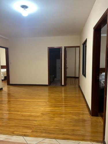 an empty room with a hard wood floor and two doors at My home in Sucúa in Sucúa