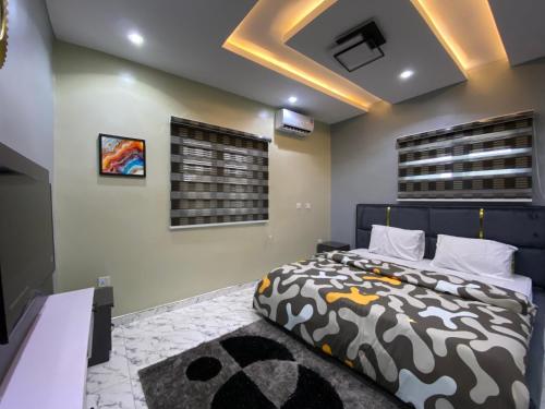 a bedroom with a large bed and a ceiling at Cozy Luxury Apartments in Sagamu