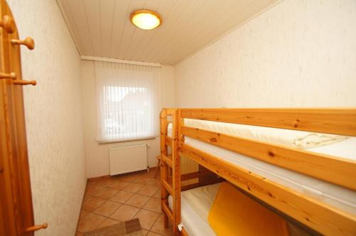 ein Zimmer mit zwei Etagenbetten und einem Fenster in der Unterkunft "Haus Stefanie" Bungalow -2- in Dahme
