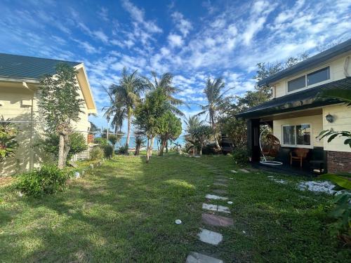 a yard next to a house with palm trees at 近月旭海莊園民宿 in Yanliau