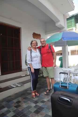 a man and a woman standing next to luggage at Guestland Homestay in Cochin