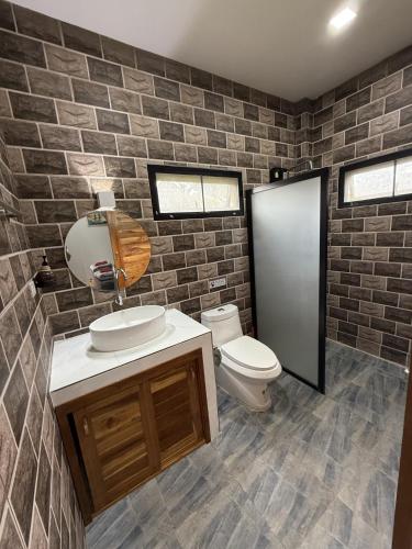 a bathroom with a sink and a toilet and a brick wall at Private Pool Residences in Ko Phangan