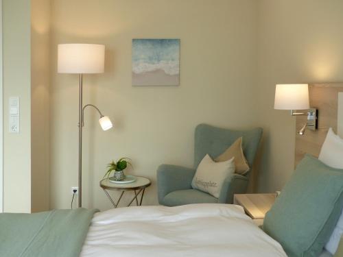 a hotel room with a bed and a chair at Hof Wittensee, Seeperle in Klein Wittensee