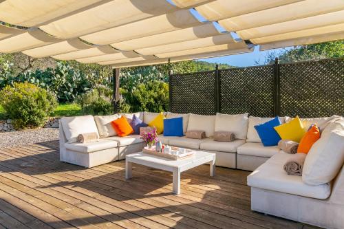 a patio with couches and a table on a wooden deck at Historical house Mallorca pool wifi airconheat in Andratx
