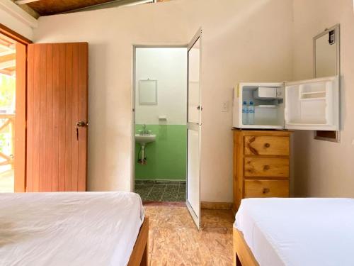 a bedroom with two beds and a sink and a mirror at Frida Paradise Beach Hotel - Punta Zicatela in Brisas de Zicatela