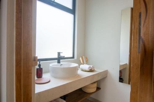 a bathroom with a sink and a window at Aymara Punta Zicatela in Brisas de Zicatela