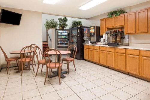a restaurant with a table and chairs and a kitchen at Quality Inn & Suites in Saint Louis