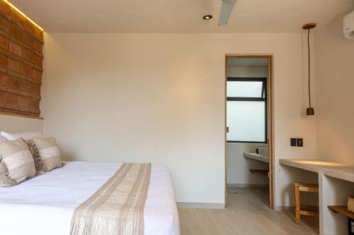a bedroom with a white bed and a window at Aymara Punta Zicatela in Brisas de Zicatela
