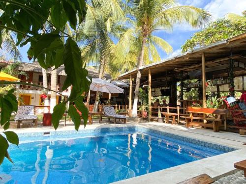 a pool at a resort with tables and chairs at Frida Paradise Beach Hotel - Punta Zicatela in Brisas de Zicatela