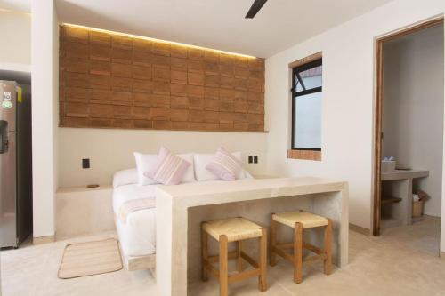 a bedroom with a white bed and two stools at Aymara Punta Zicatela in Brisas de Zicatela
