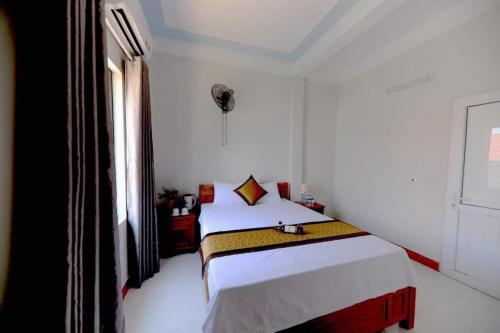 a white bedroom with a bed and a window at Family homestay in Bố Trạch