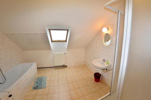 La salle de bains est pourvue d'un lavabo, d'une baignoire et d'une douche. dans l'établissement Penzion Poodří, à Suchdol nad Odrou