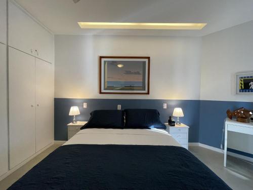 una camera da letto con un letto grande con pareti blu di Flat Maravilhoso Copacabana (BestHostRio) a Rio de Janeiro