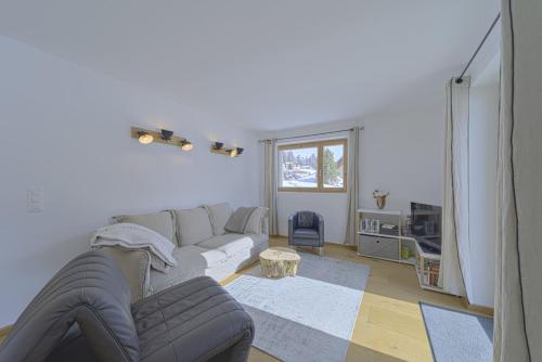 a living room with a couch and a table at Chesa Muntanella - Samedan in Samedan