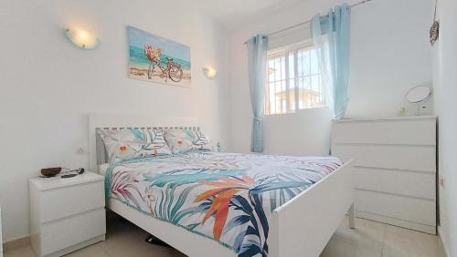 a white bedroom with a bed and a window at La Siesta Perfecta in Villacosta