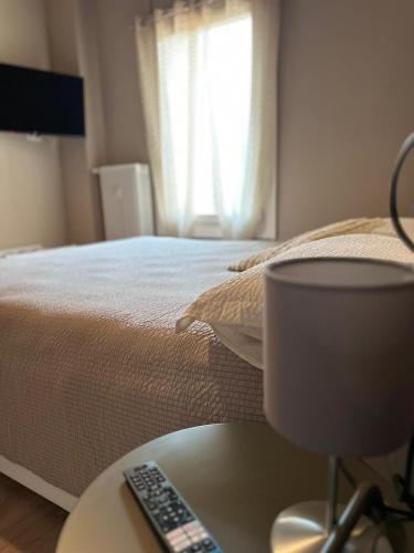a bedroom with a bed and a table with a remote control at Casa di Otti in Ivrea