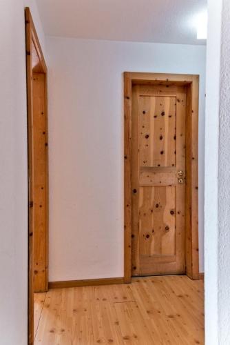 an empty room with a door and wooden floors at Chesa Dal Gial - Celerina in Celerina