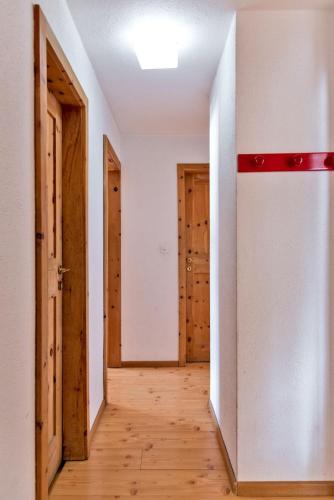an empty hallway with two doors and wooden floors at Chesa Dal Gial - Celerina in Celerina