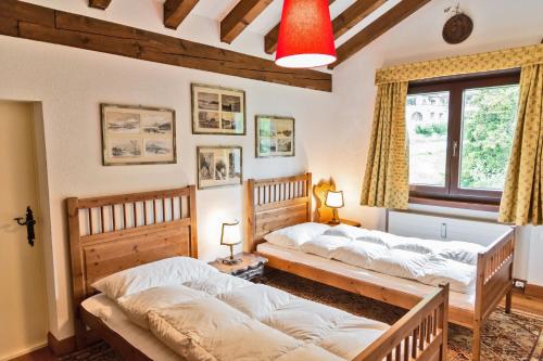 two twin beds in a room with a window at Chesa Martina - La Punt in La Punt-Chamues-ch