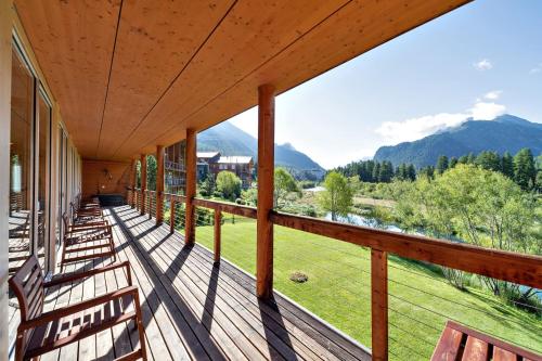 a porch with chairs and a view of the mountains at Chesa Rivarel - Pontresina in Pontresina