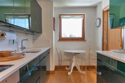 a kitchen with a sink and a table in it at Chesa Viroula - Zuoz in Zuoz