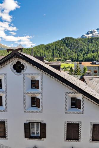 a white building with a cross on the top of it at Chesa Cromer - Celerina in Celerina