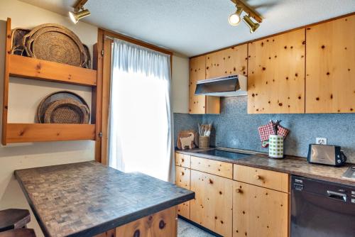 a kitchen with wooden cabinets and a counter top at Chesa Cromer - Celerina in Celerina