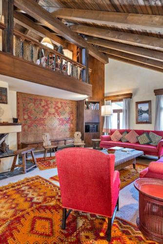 a living room with a red couch and a red chair at Chesa Cromer - Celerina in Celerina