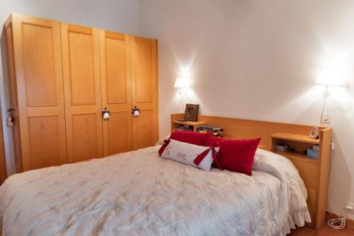 a bedroom with a bed with two red pillows at Chesa Pedra - Celerina in Celerina