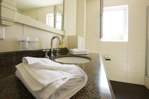 ein Bad mit einem Waschbecken und Handtüchern darauf in der Unterkunft Waldcafé Hotel Restaurant in Baden-Baden