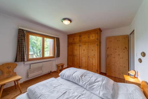 a bedroom with a bed and a window at Chesa Gravulaina - Madulain in Madulain