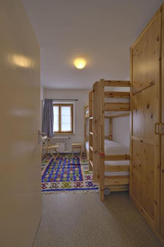 a bedroom with a bunk bed and a bedroom with a window at Chesa Giandains - Pontresina in Pontresina