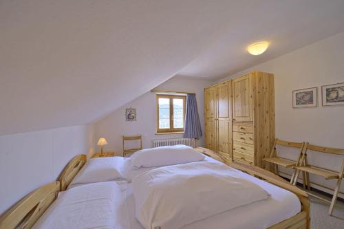 a bedroom with two beds and a window at Chesa Giandains - Pontresina in Pontresina
