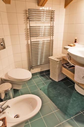 a bathroom with two toilets and a sink and a tub at Chalet Gulas - La Punt-Chamues-ch in La Punt-Chamues-ch