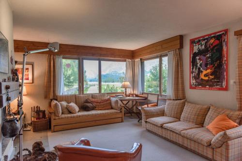 a living room with couches and a table and windows at Chesa Muot Marias - Sils in Sils Maria