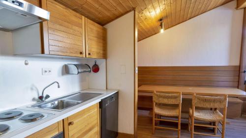 a kitchen with a sink and a table with chairs at Chesa Sarvit 1 - Celerina in Celerina