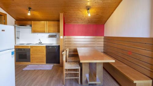 a kitchen with a wooden table and a refrigerator at Chesa Sarvit 1 - Celerina in Celerina