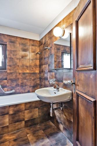a bathroom with wooden walls and a sink and a tub at Chesa Chavriol 2 - Celerina in Celerina