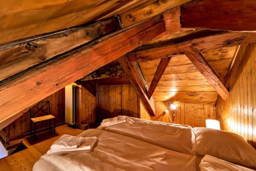 a bed in a room with wooden ceilings at Chesa La Cuntainta - Sils Maria in Sils Maria