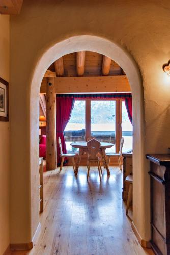 an archway in a room with a table and chairs at Chesa Romana - Silvaplana in Silvaplana