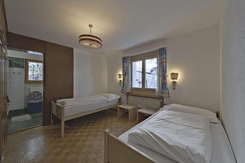 a hospital room with two beds and a shower at Chesa Chavriol - Samedan in Samedan