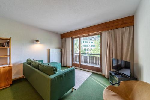 a living room with a couch and a large window at Chesa Muot Marias - Sils in Sils Maria