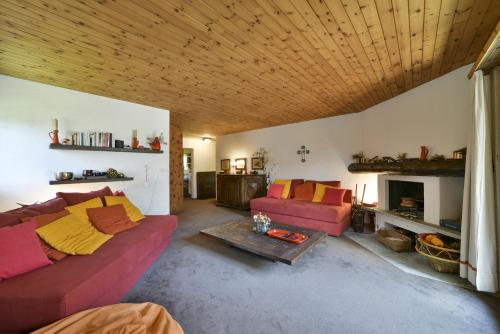 a living room with two couches and a wooden ceiling at Chesa Bursella - Madulain in Madulain