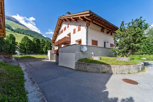 a white building with a wooden roof at Chesa Sur Naiv - Celerina in Celerina