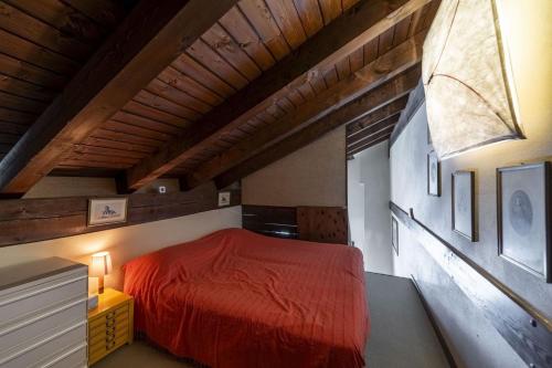 a bedroom with a red bed in a attic at Chesa Ste Attic - Celerina in Celerina